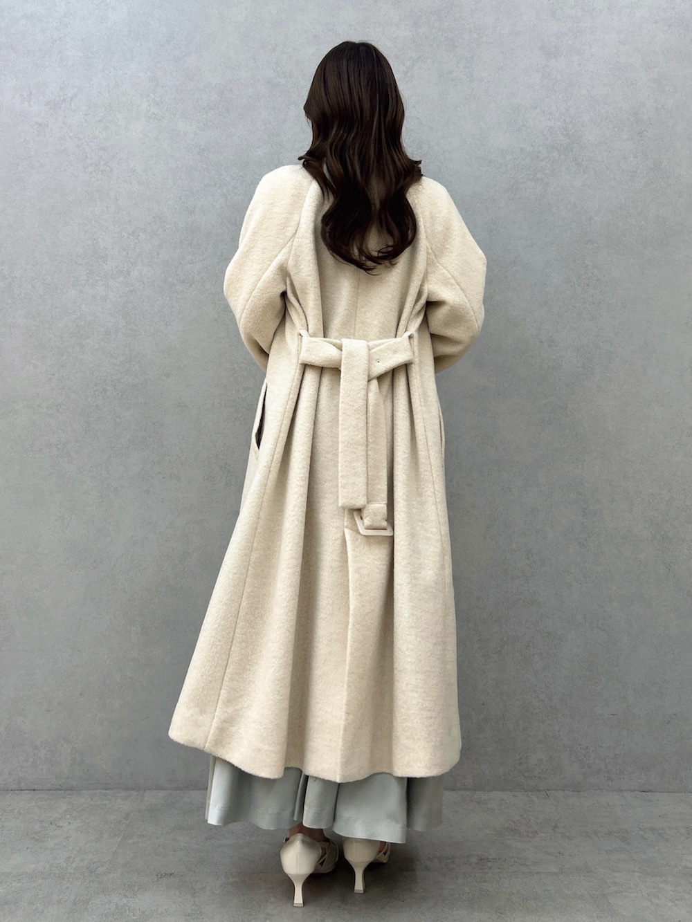 ホワイト系のその他アウター、グリーン系のドレス、ホワイト系のパンプスを着用したレディースの冬コーディネートの4枚目の写真