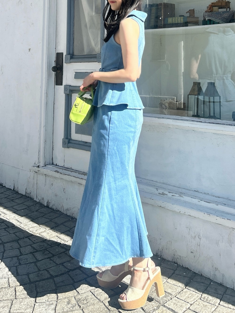 ブルー系のワンピース、ホワイト系のサンダル、イエロー系のハンドバッグを着用したレディースの春コーディネートの5枚目の写真