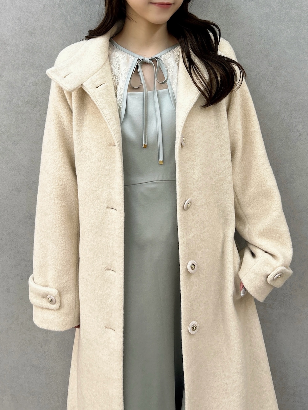 ホワイト系のその他アウター、グリーン系のドレス、ホワイト系のパンプスを着用したレディースの冬コーディネートの8枚目の写真