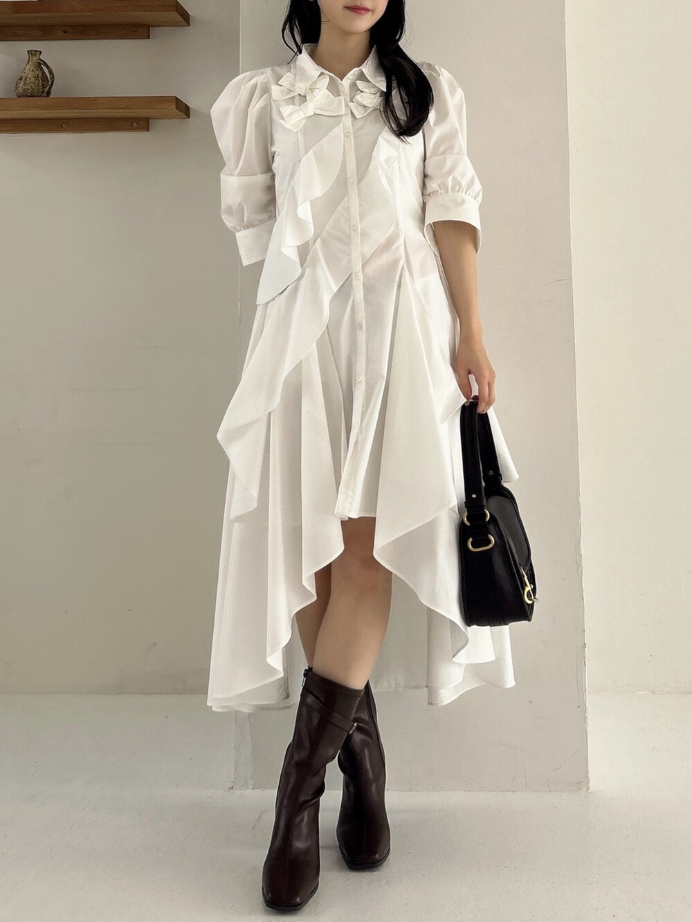 ホワイト系のワンピース、ブラウン系のブーツを着用したレディースの冬コーディネートの2枚目の写真