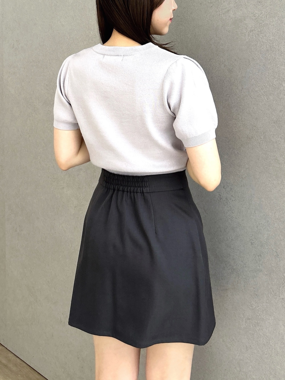 グレー系のニット/セーター、グレー系のスカートを着用したレディースの春コーディネートの5枚目の写真