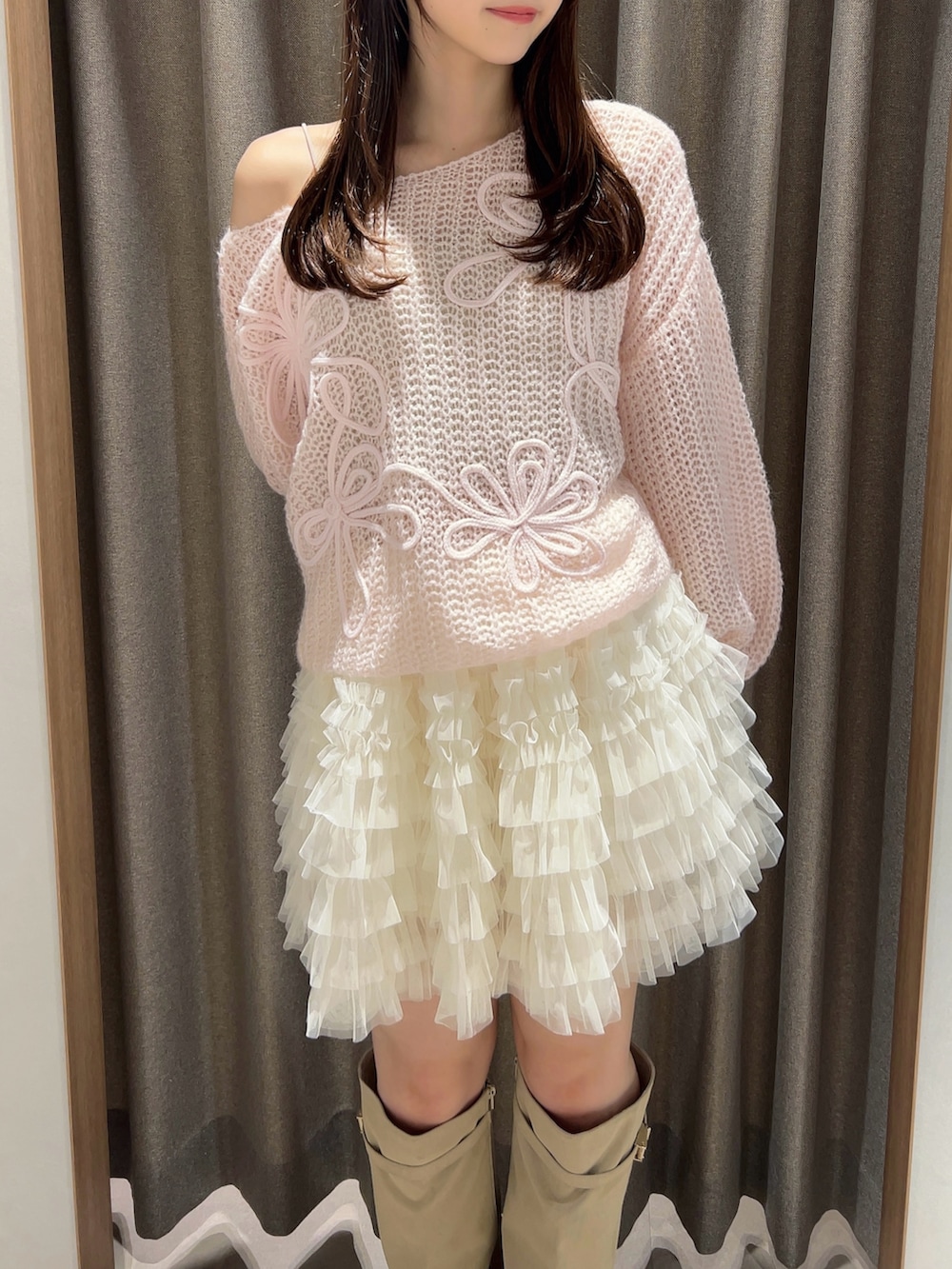 ピンク系のニット/セーター、ホワイト系のスカート、ホワイト系のブーツを着用したレディースの秋コーディネートの9枚目の写真