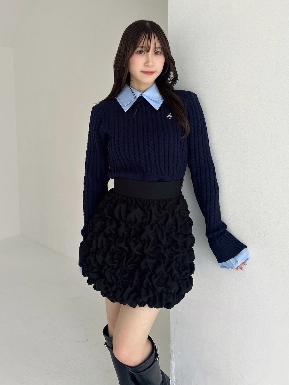 ブラック系のブーツ、ブラック系のスカート、ブルー系のニット/セーターを着用したレディースの冬コーディネートの7枚目の写真