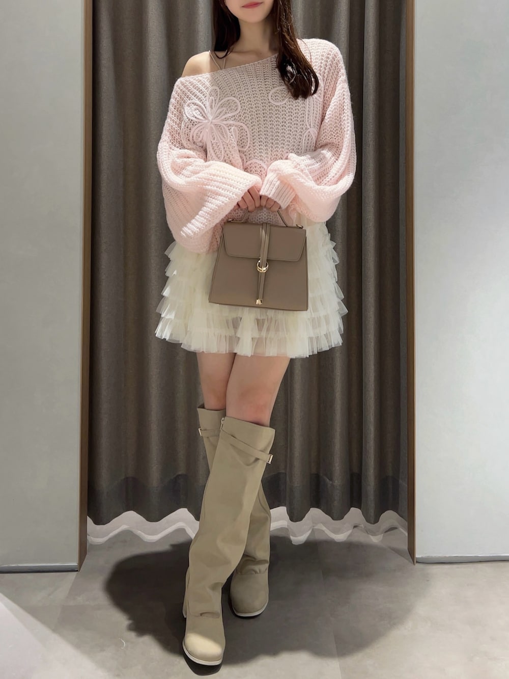 ピンク系のニット/セーター、ホワイト系のスカート、ホワイト系のブーツを着用したレディースの秋コーディネートの3枚目の写真
