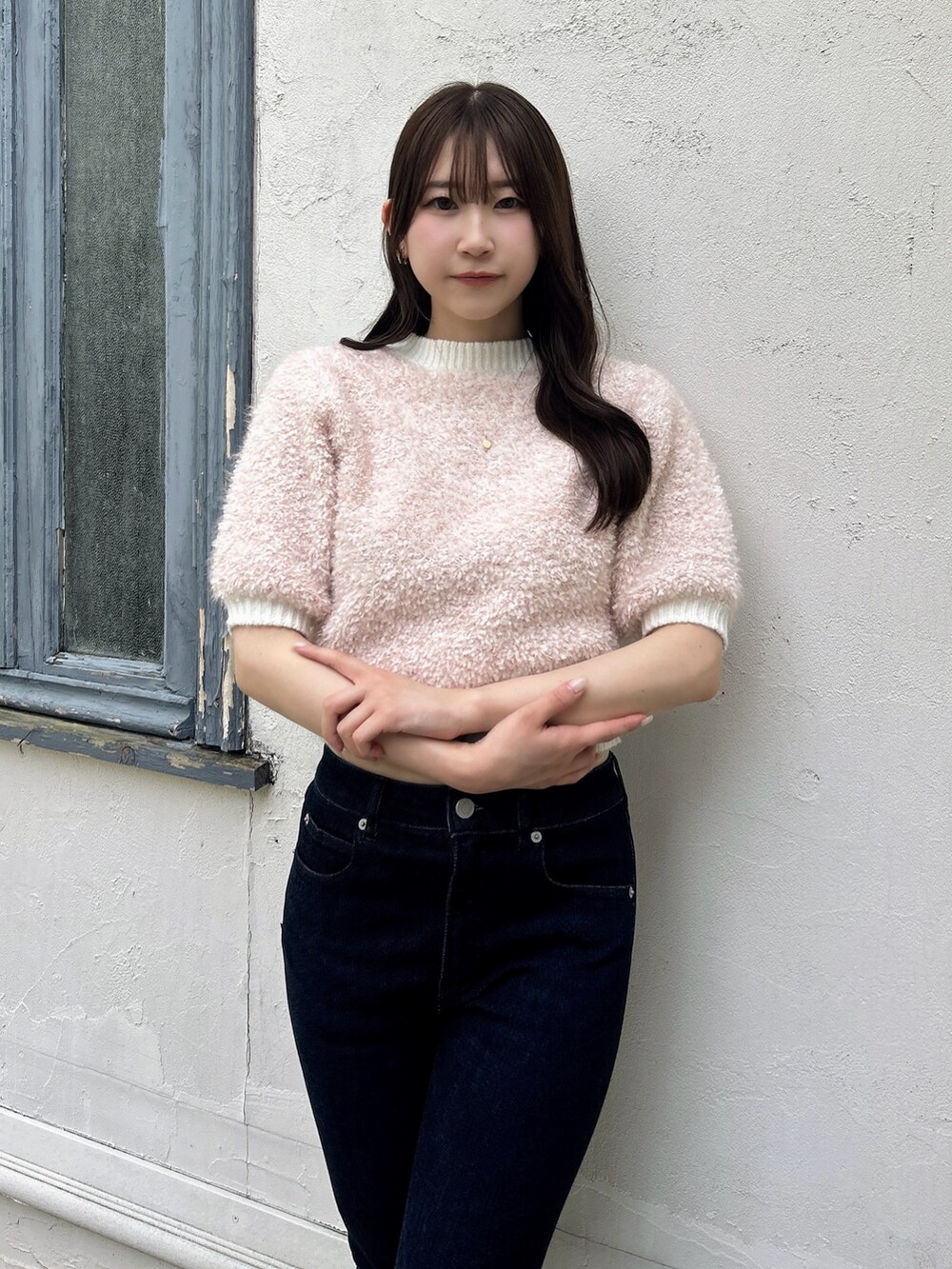 ピンク系のニット/セーター、ブルー系のデニムパンツを着用したレディースの夏コーディネートの6枚目の写真