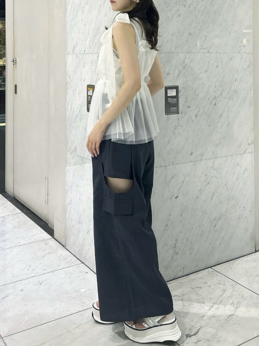 グレー系のニット/セーター、ホワイト系のタンクトップ、ホワイト系のサンダルを着用したレディースの夏コーディネートの5枚目の写真
