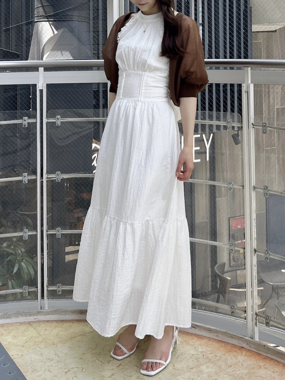 ブラウン系のカーディガン/ボレロ、ホワイト系のワンピース、ホワイト系のワンピースを着用したレディースの夏コーディネートの4枚目の写真