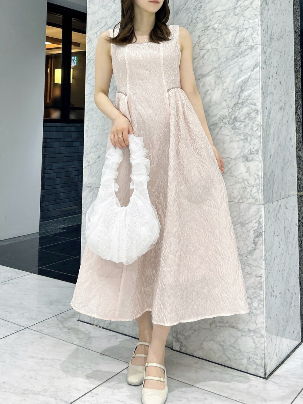 ホワイト系のパンプス、ホワイト系のハンドバッグ、ピンク系のドレスを着用したレディースの夏コーディネートの3枚目の写真