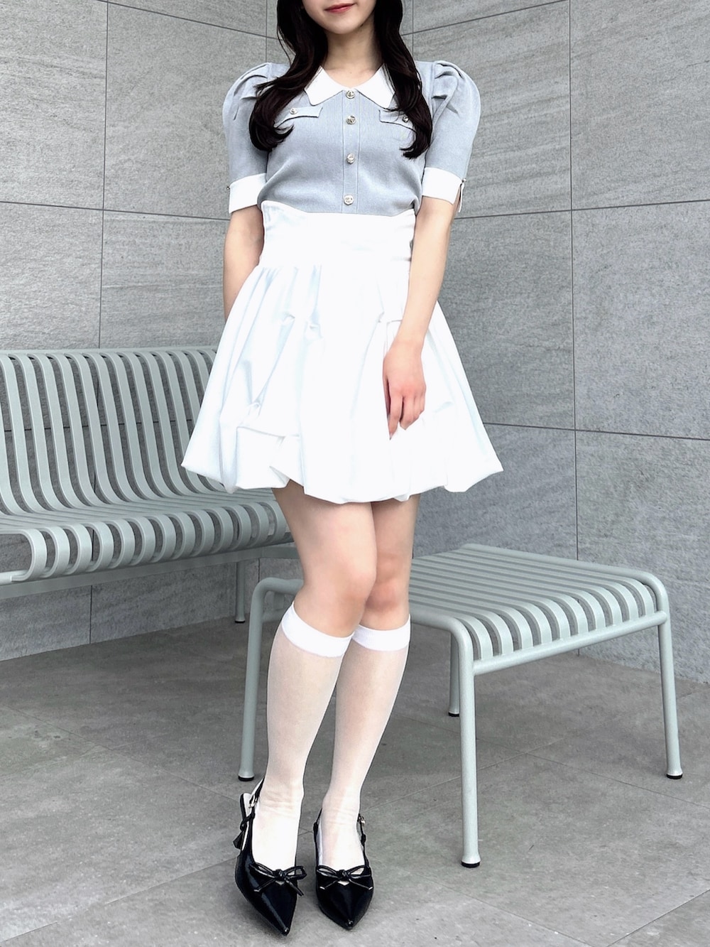 グレー系のニット/セーター、ホワイト系のスカートを着用したレディースの冬コーディネートの5枚目の写真