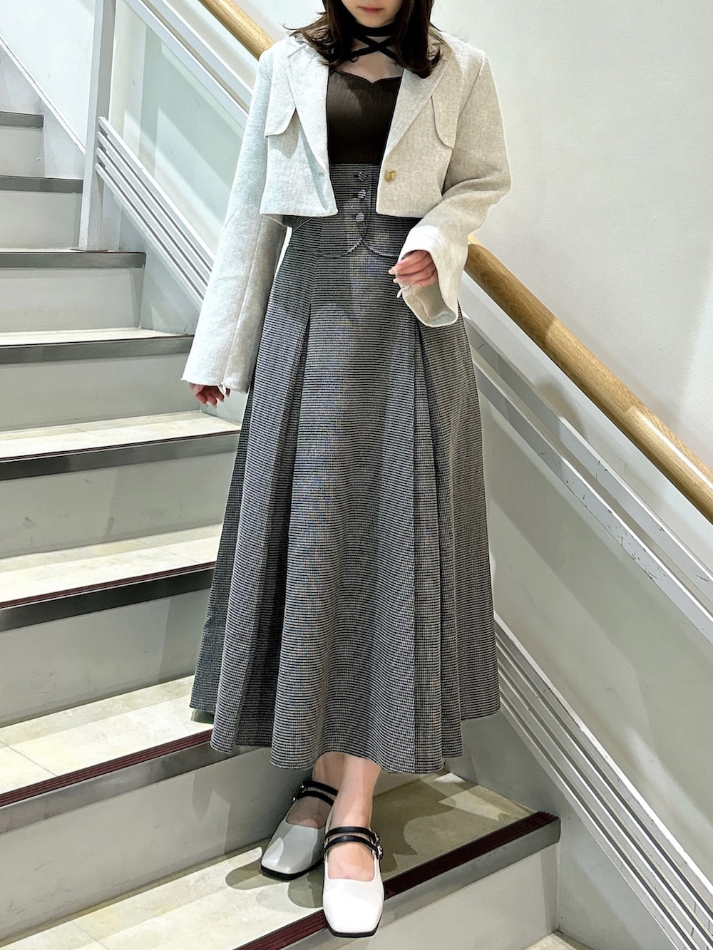 ブラウン系のワンピース、ホワイト系のテーラードジャケット、ベージュ系のパンプスを着用したレディースの秋コーディネートの2枚目の写真