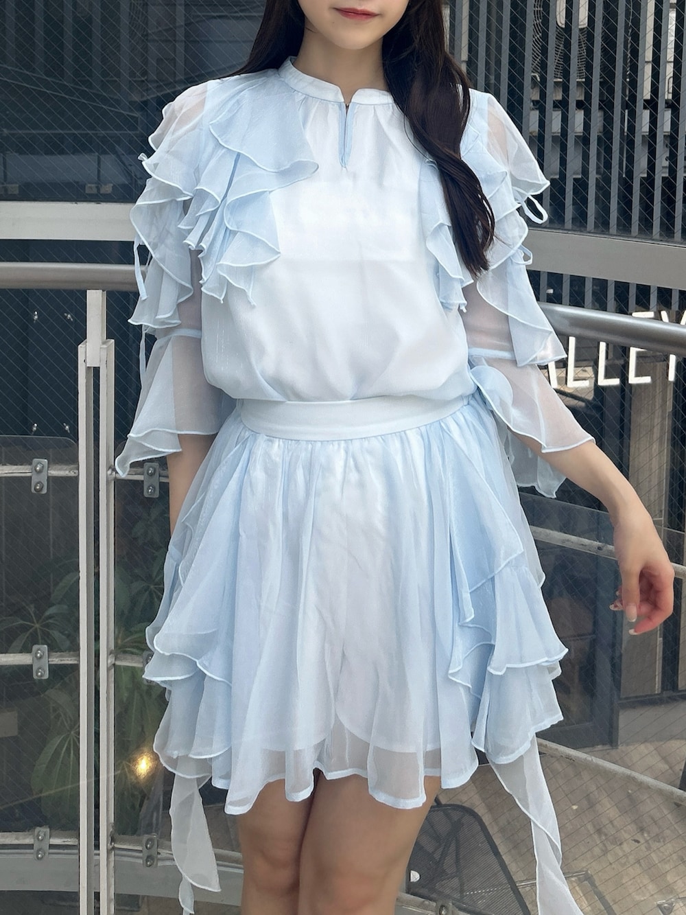 ブルー系のシャツ/ブラウス、ブルー系のスカート、ホワイト系のサンダルを着用したレディースの秋コーディネートの7枚目の写真