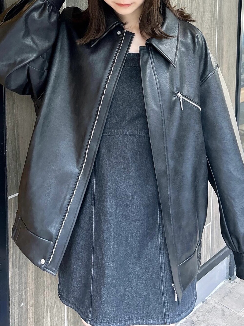 ブラック系のブルゾン、ブラック系のワンピース、ブラック系のブーツを着用したレディースの春コーディネートの8枚目の写真