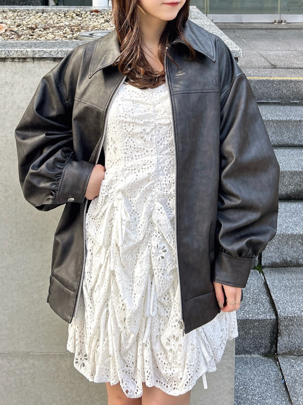 ブラック系のブルゾン、ホワイト系のワンピースを着用したレディースの冬コーディネートの7枚目の写真