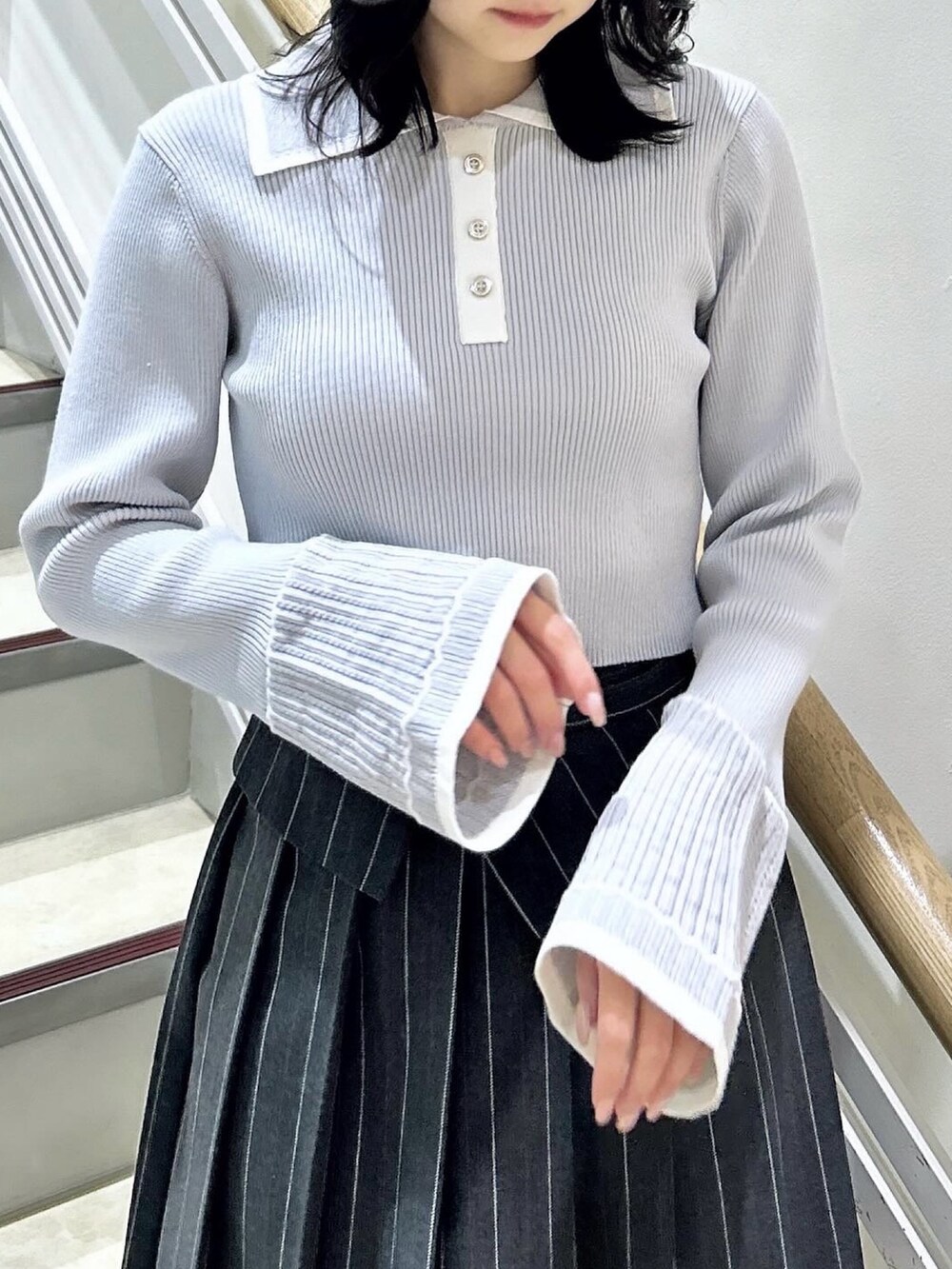 グレー系のニット/セーター、グレー系のスカート、ブラック系のブーツを着用したレディースの冬コーディネートの8枚目の写真