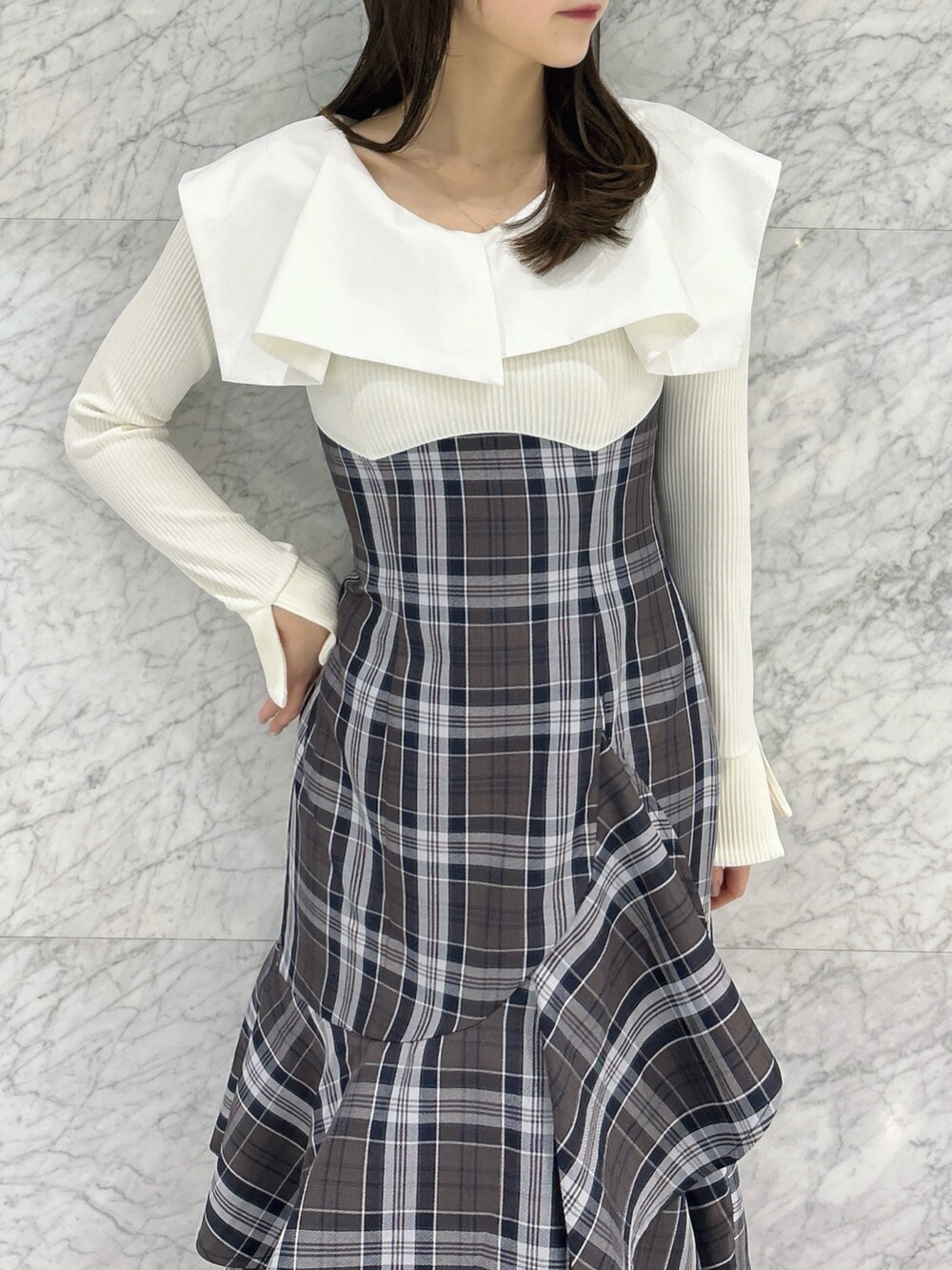 ホワイト系のワンピース、ベージュ系のブーツを着用したレディースの冬コーディネートの7枚目の写真