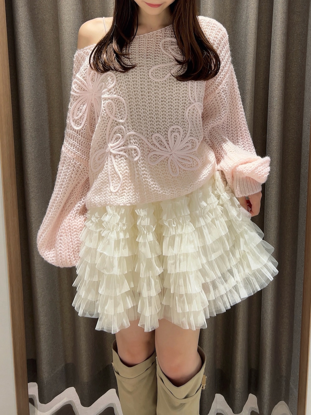 ピンク系のニット/セーター、ホワイト系のスカート、ホワイト系のブーツを着用したレディースの秋コーディネートの8枚目の写真