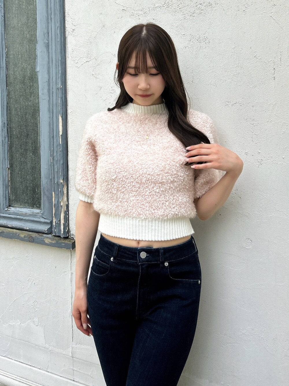 ピンク系のニット/セーター、ブルー系のデニムパンツを着用したレディースの夏コーディネートの7枚目の写真