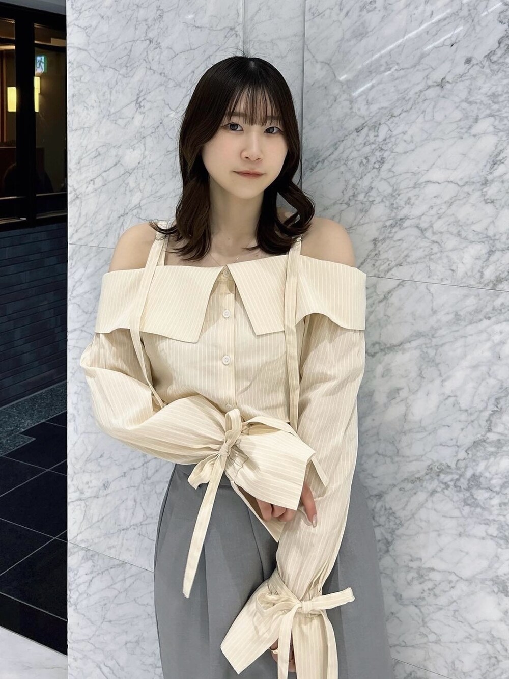 グレー系のスカート、シルバー系のパンプス、イエロー系のシャツ/ブラウスを着用したレディースの春コーディネートの6枚目の写真