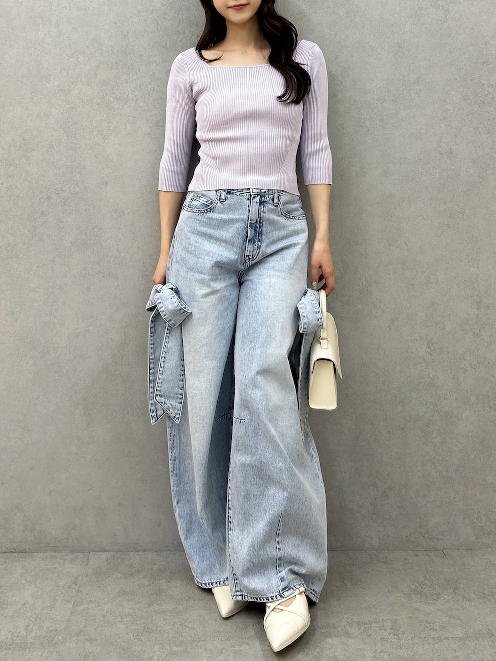 パープル系のニット/セーター、ブルー系のデニムパンツ、ホワイト系のパンプスを着用したレディースの冬コーディネートの3枚目の写真