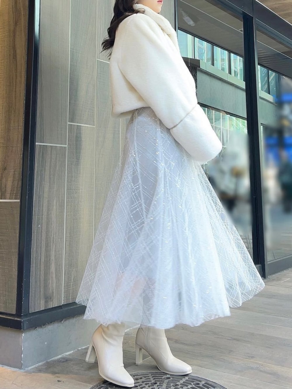 ホワイト系のその他アウター、ホワイト系のブーツ、ホワイト系のニット/セーターを着用したレディースの冬コーディネートの4枚目の写真