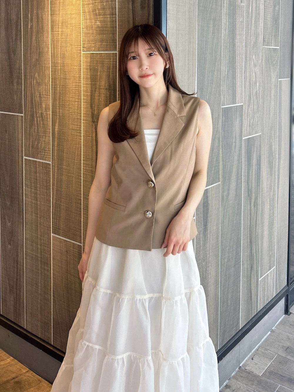 ブラウン系のベスト、ホワイト系のTシャツ/カットソー、ベージュ系のスカートを着用したレディースの秋コーディネートの8枚目の写真