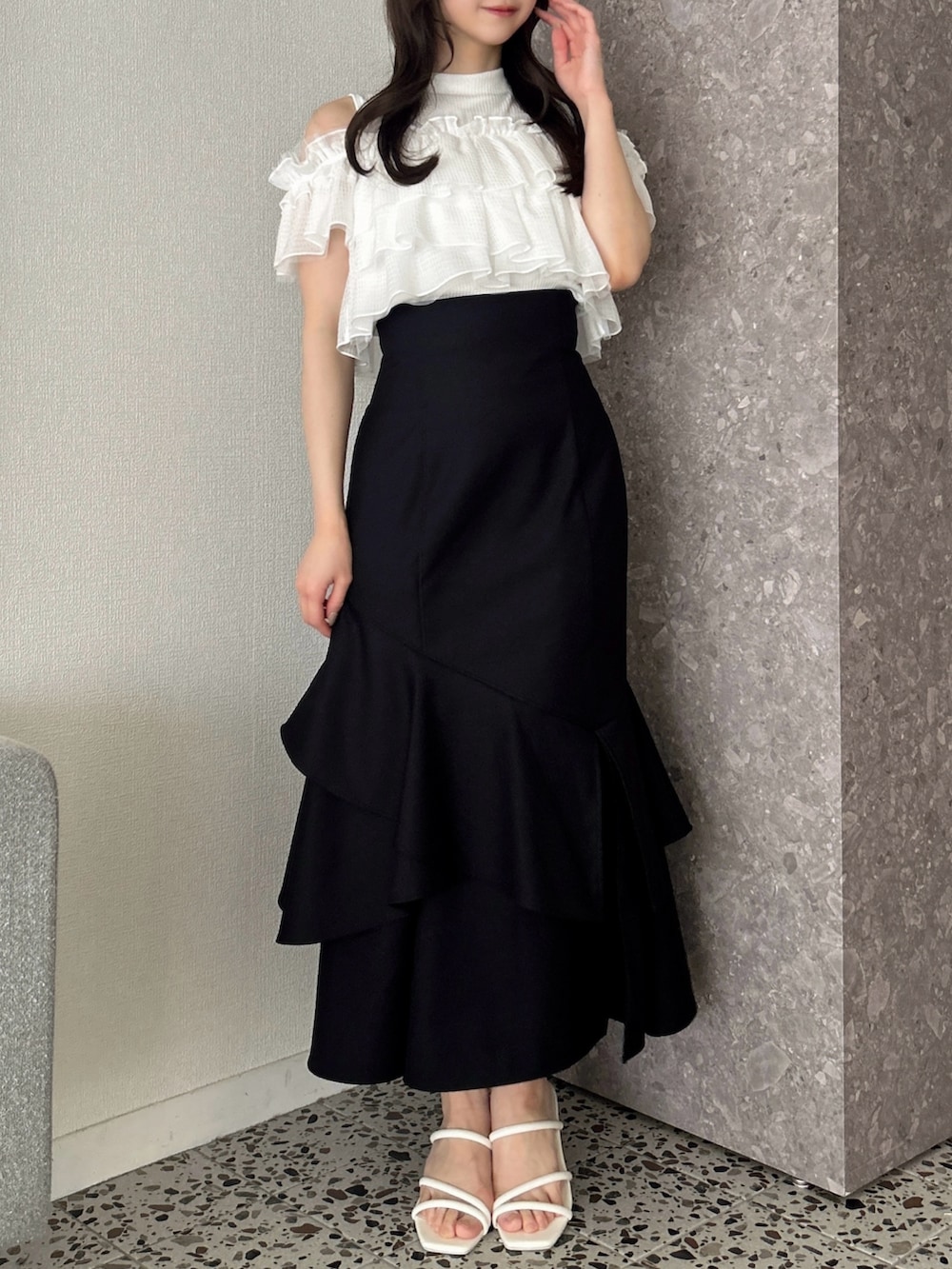 ホワイト系のTシャツ/カットソー、ブラック系のスカート、ホワイト系のサンダルを着用したレディースの春コーディネートの2枚目の写真