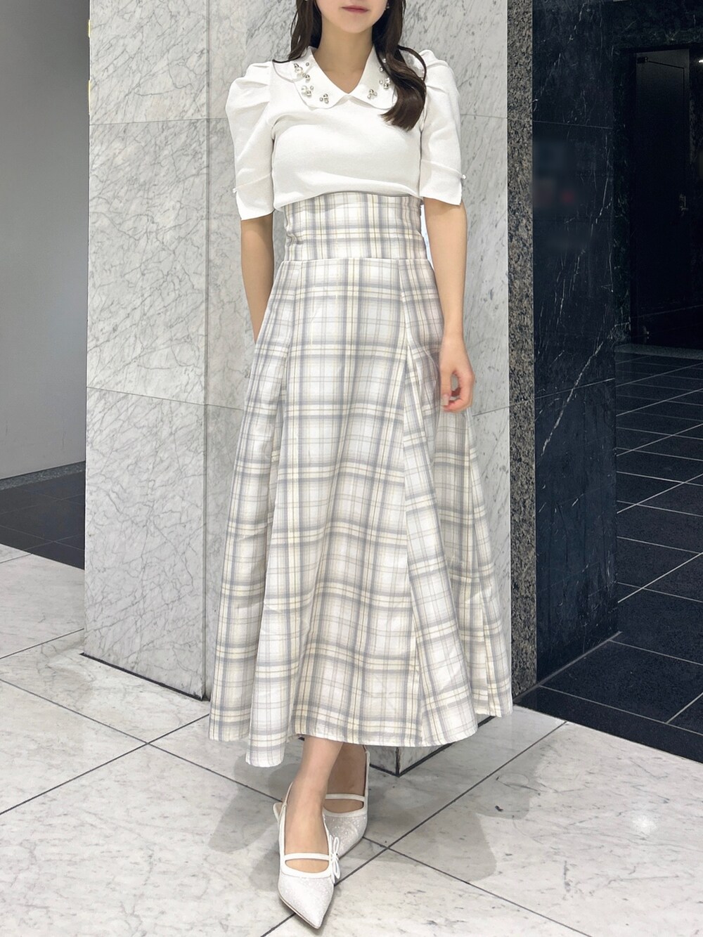 ホワイト系のニット/セーター、イエロー系のスカート、ホワイト系のパンプスを着用したレディースの春コーディネートの2枚目の写真