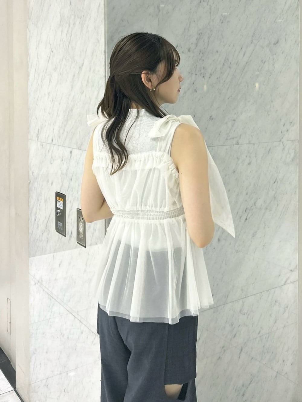 グレー系のニット/セーター、ホワイト系のタンクトップ、ホワイト系のサンダルを着用したレディースの夏コーディネートの10枚目の写真
