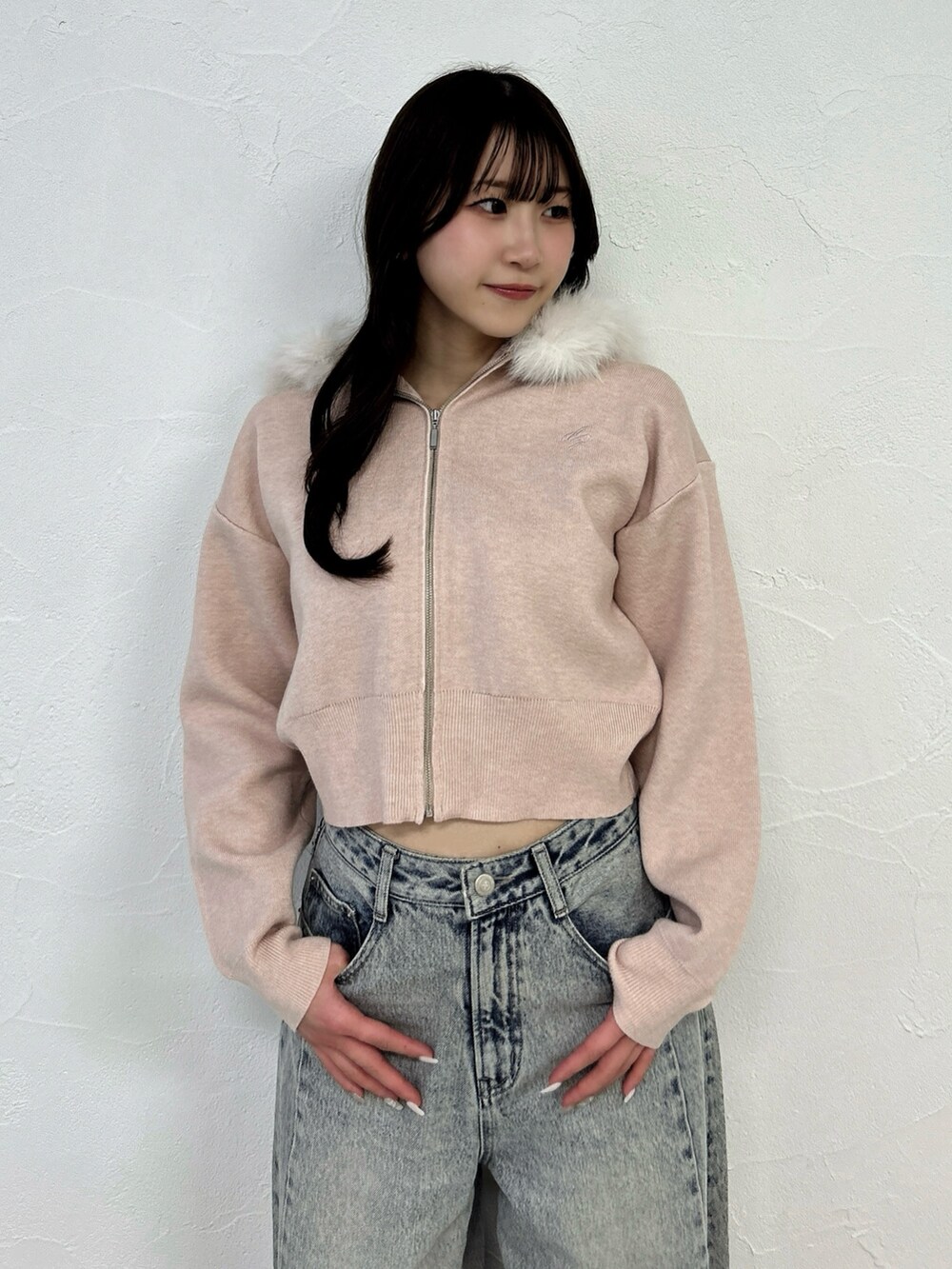 ピンク系のニット/セーター、ブルー系のデニムパンツを着用したレディースの冬コーディネートの9枚目の写真