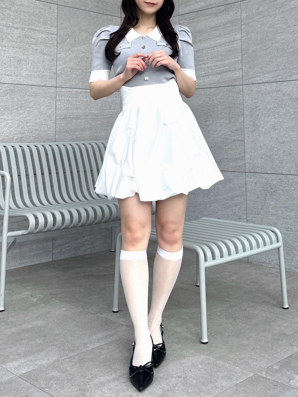 グレー系のニット/セーター、ホワイト系のスカートを着用したレディースの冬コーディネートの3枚目の写真