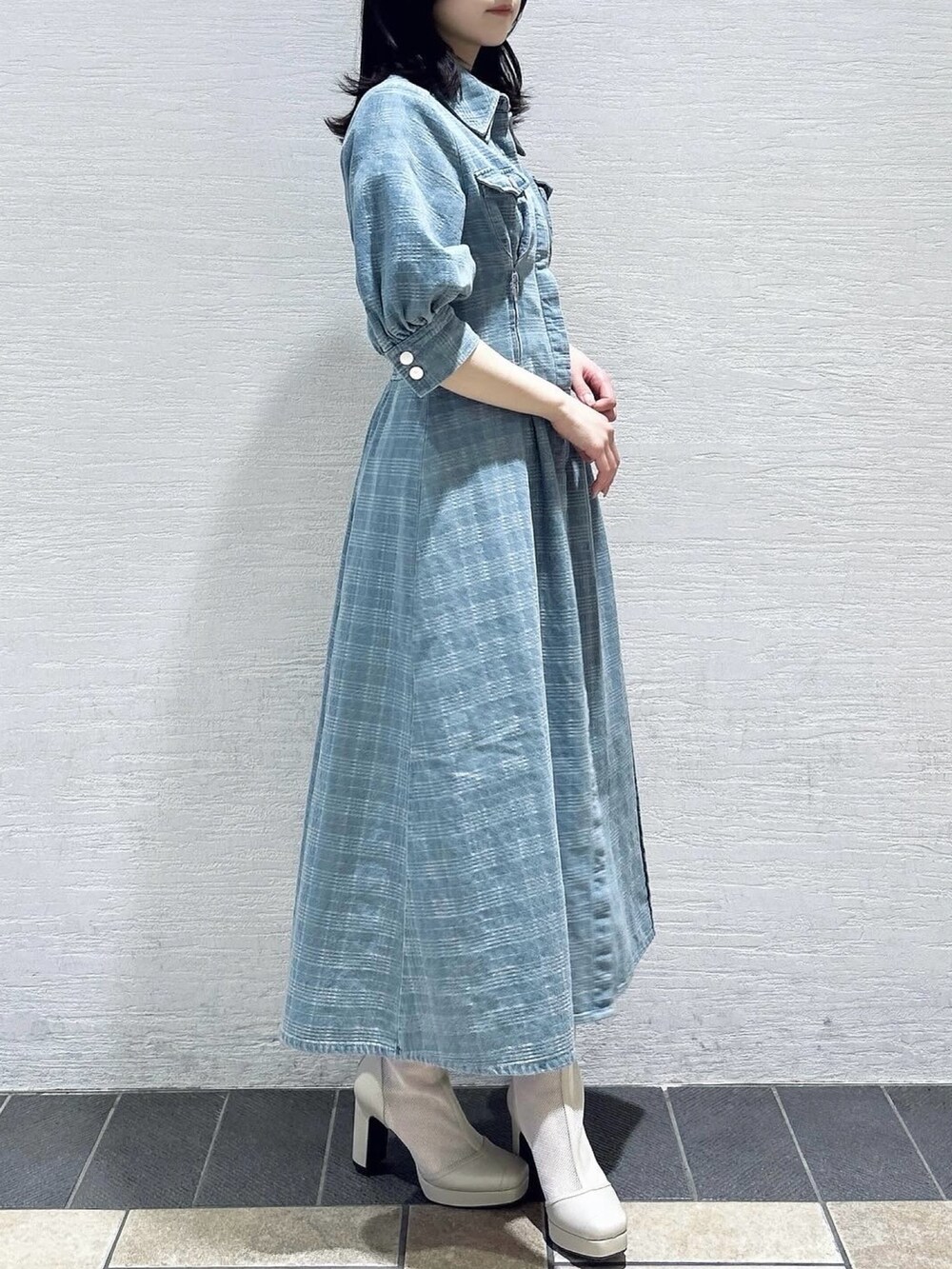 ブルー系のワンピース、ホワイト系のブーツを着用したレディースの冬コーディネートの3枚目の写真