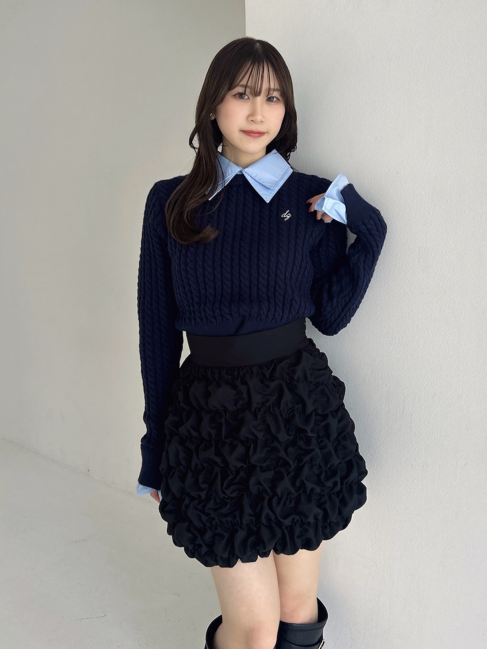 ブラック系のブーツ、ブラック系のスカート、ブルー系のニット/セーターを着用したレディースの冬コーディネートの9枚目の写真