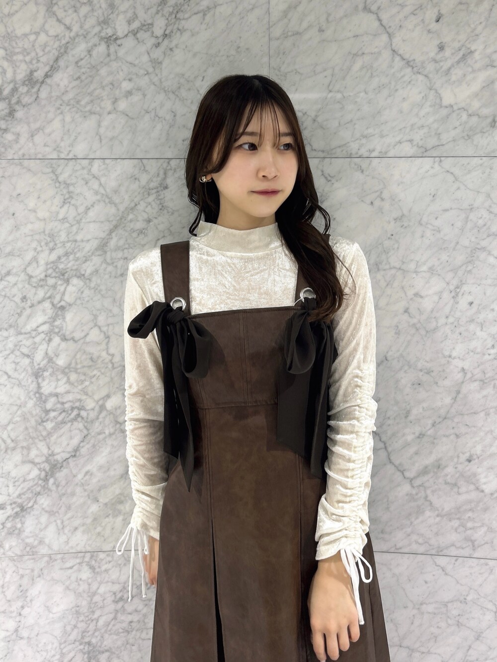 ホワイト系のTシャツ/カットソー、ブラウン系のワンピース、その他のブーツを着用したレディースの冬コーディネートの6枚目の写真