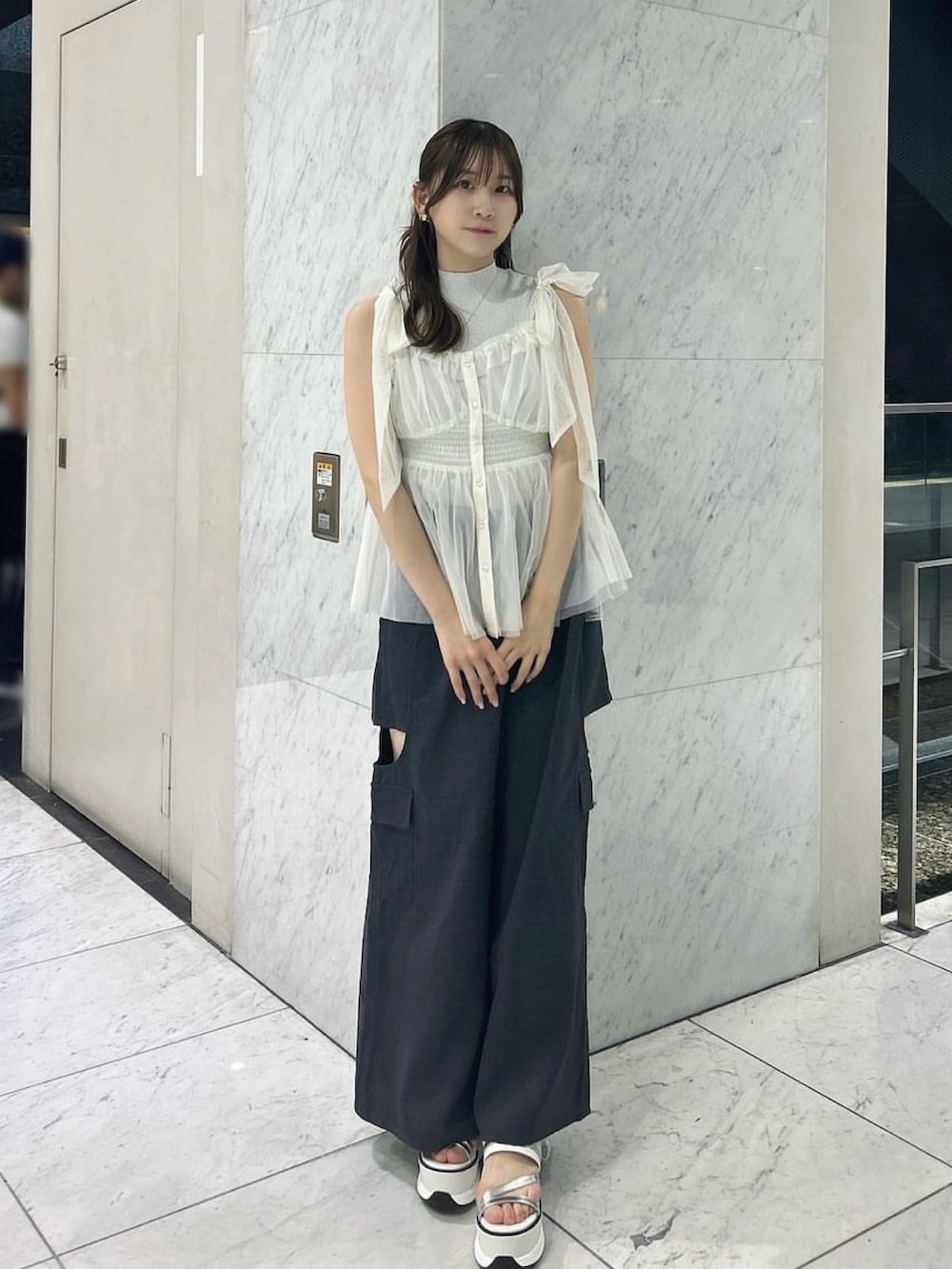 グレー系のニット/セーター、ホワイト系のタンクトップ、ホワイト系のサンダルを着用したレディースの夏コーディネートの2枚目の写真