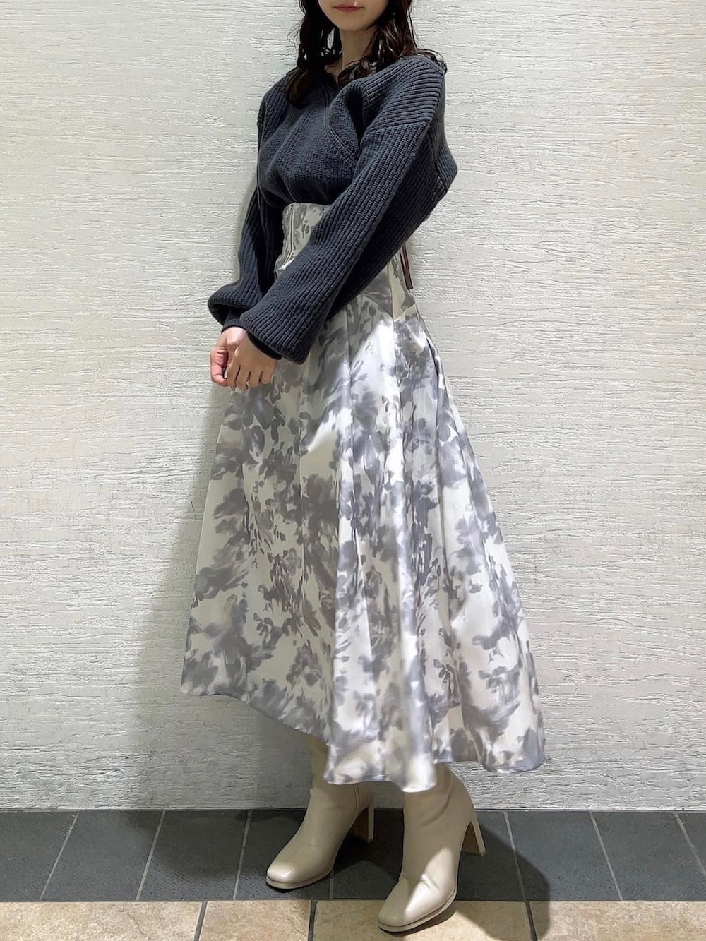 ホワイト系のスカート、ホワイト系のブーツ、グレー系のニット/セーターを着用したレディースの冬コーディネートの4枚目の写真