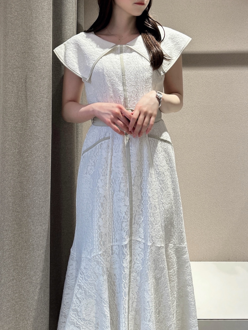 ホワイト系のワンピース、ホワイト系のサンダル、ブラック系のかごバッグを着用したレディースの夏コーディネートの8枚目の写真