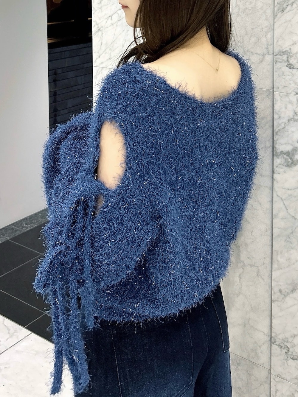 ブルー系のニット/セーター、ブルー系のデニムパンツ、ホワイト系のパンプスを着用したレディースの夏コーディネートの8枚目の写真