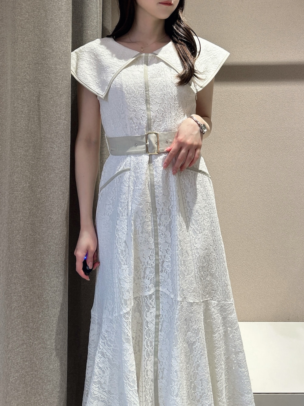 ホワイト系のワンピース、ホワイト系のサンダル、ブラック系のかごバッグを着用したレディースの夏コーディネートの9枚目の写真