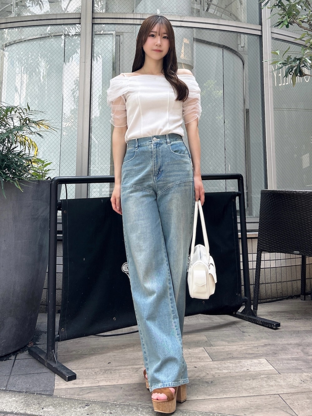 ホワイト系のTシャツ/カットソー、ブルー系のデニムパンツ、ブラウン系のサンダルを着用したレディースの夏コーディネートの3枚目の写真