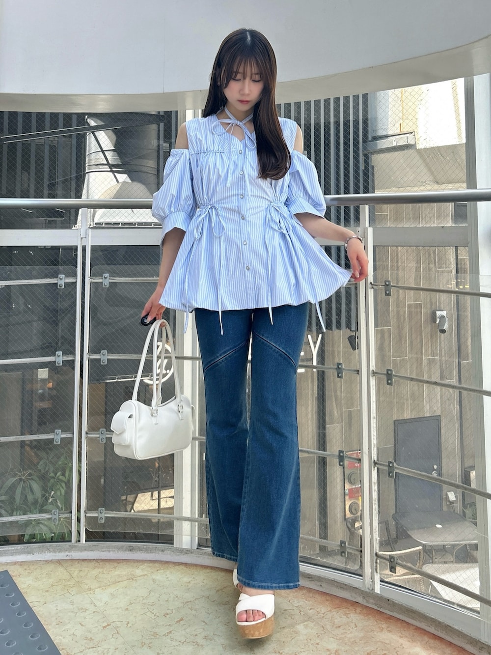 ブルー系のシャツ/ブラウス、ブルー系のデニムパンツ、ホワイト系のサンダルを着用したレディースの秋コーディネートの3枚目の写真