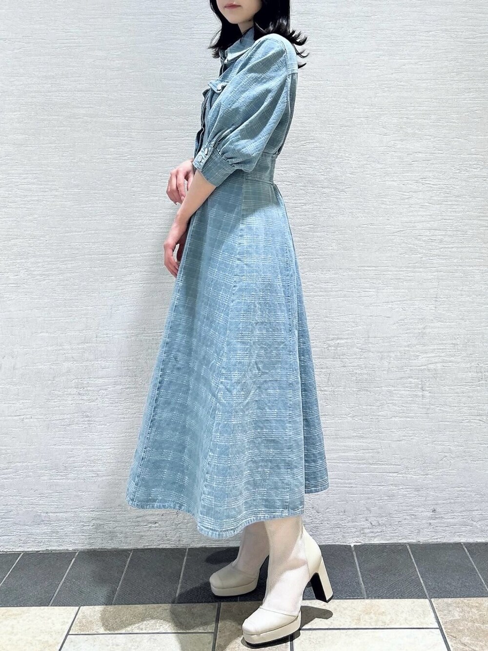 ブルー系のワンピース、ホワイト系のブーツを着用したレディースの冬コーディネートの4枚目の写真