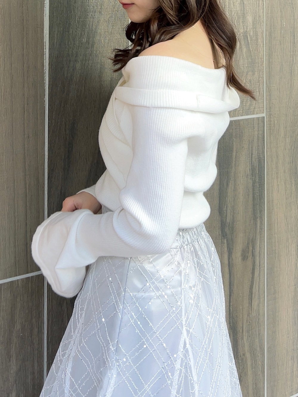 ホワイト系のニット/セーター、グレー系のスカート、ホワイト系のブーツを着用したレディースの冬コーディネートの8枚目の写真