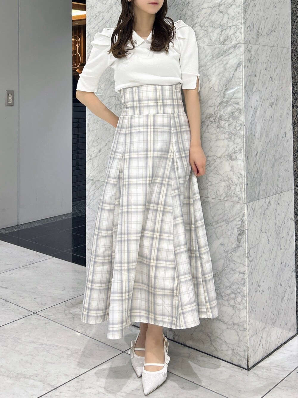 ホワイト系のニット/セーター、イエロー系のスカート、ホワイト系のパンプスを着用したレディースの春コーディネートの4枚目の写真