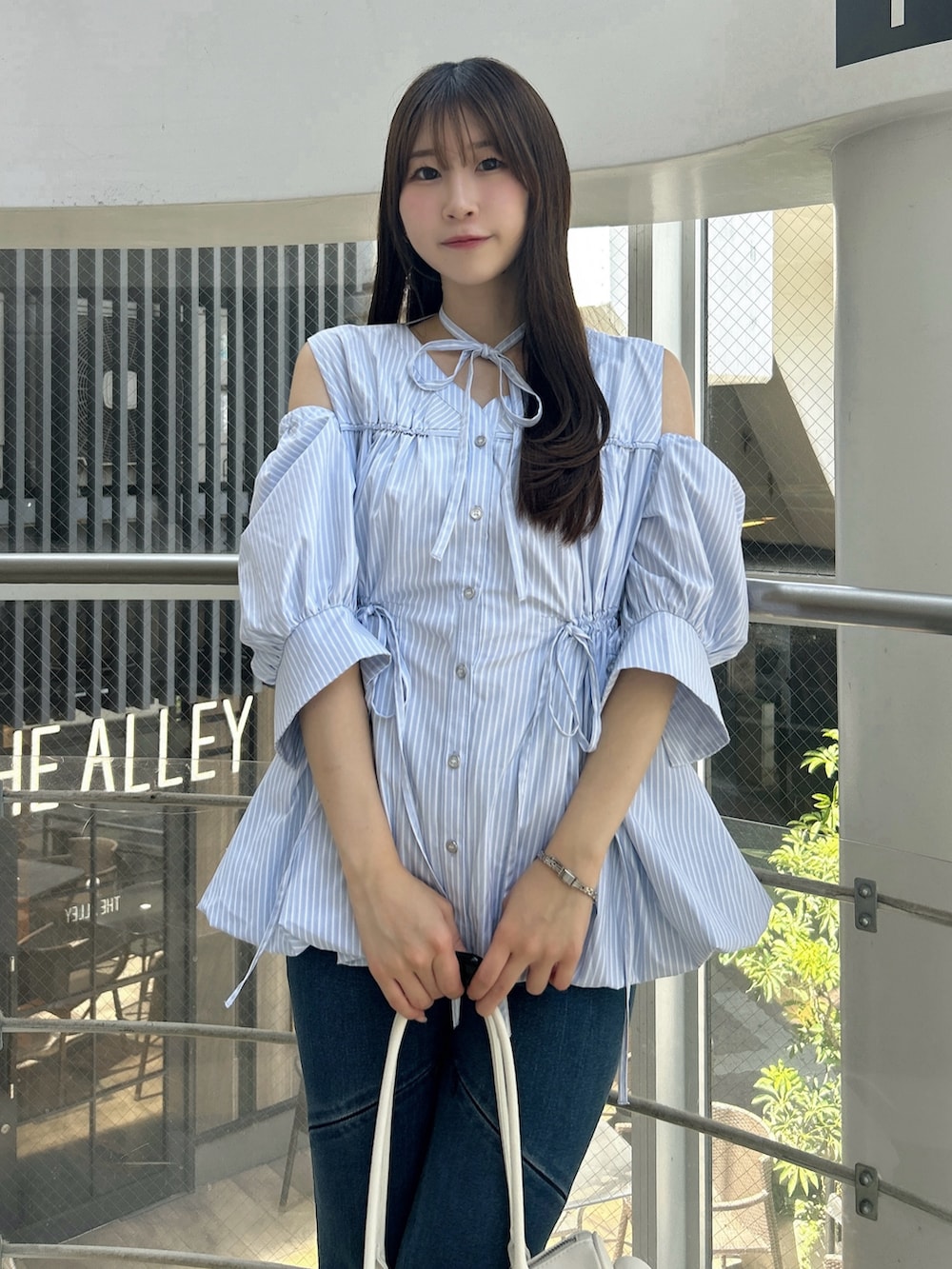 ブルー系のシャツ/ブラウス、ブルー系のデニムパンツ、ホワイト系のサンダルを着用したレディースの秋コーディネートの6枚目の写真