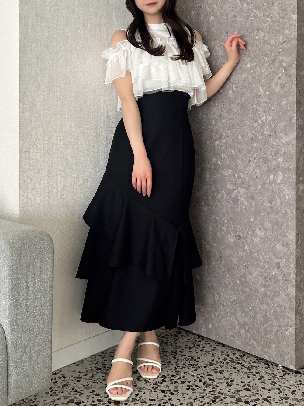 ホワイト系のTシャツ/カットソー、ブラック系のスカート、ホワイト系のサンダルを着用したレディースの春コーディネートの4枚目の写真