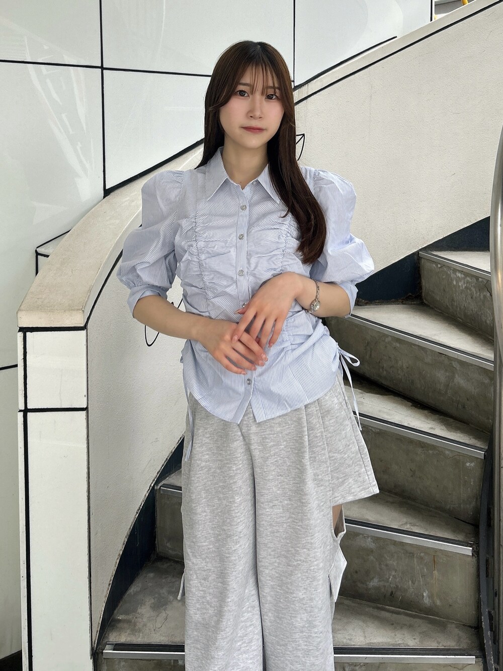 ブルー系のシャツ/ブラウス、グレー系のカーゴパンツ、ホワイト系のパンプスを着用したレディースの夏コーディネートの7枚目の写真