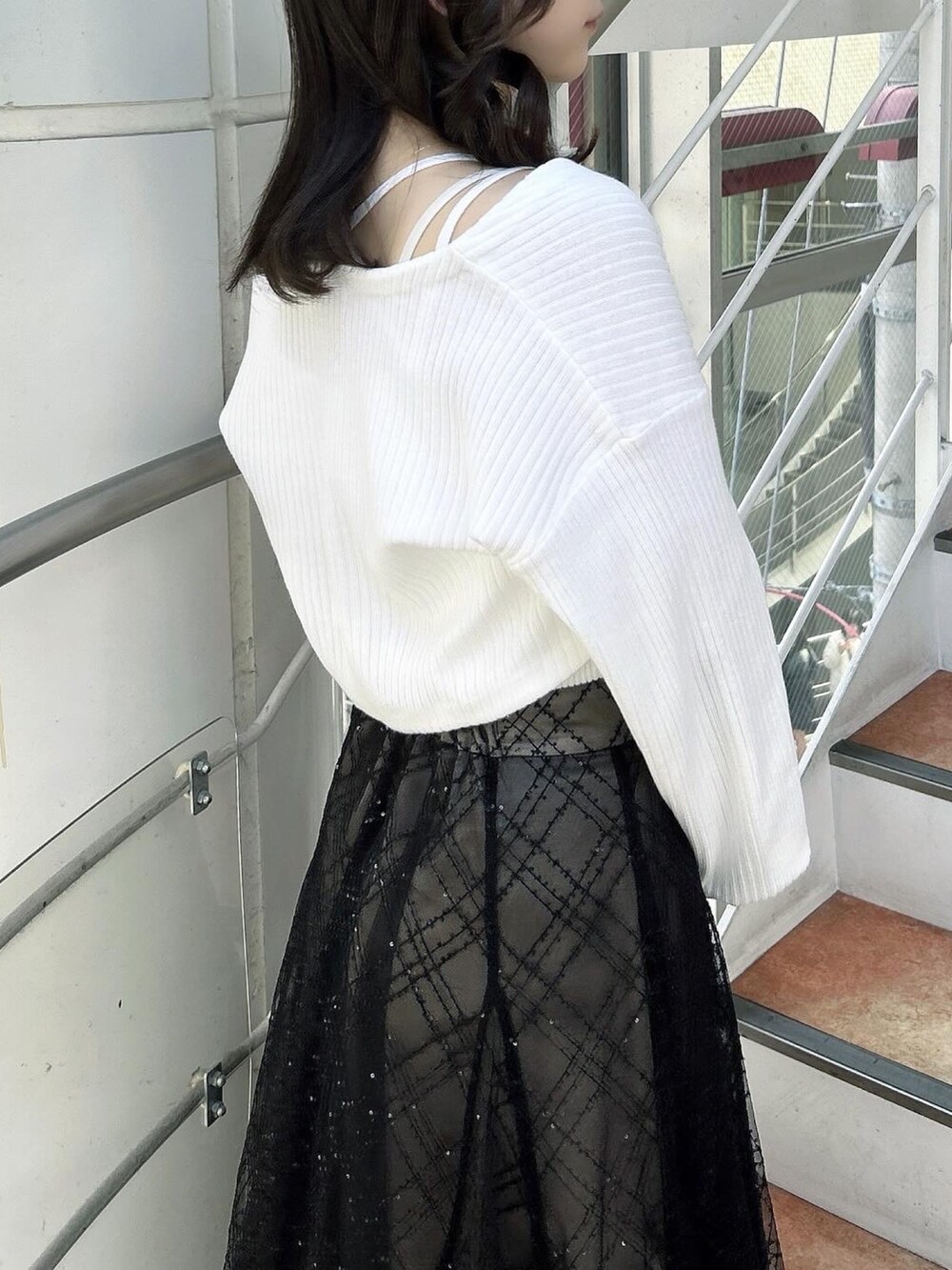 ホワイト系のアンサンブル、ブラック系のスカート、ブラック系のパンプスを着用したレディースの春コーディネートの9枚目の写真