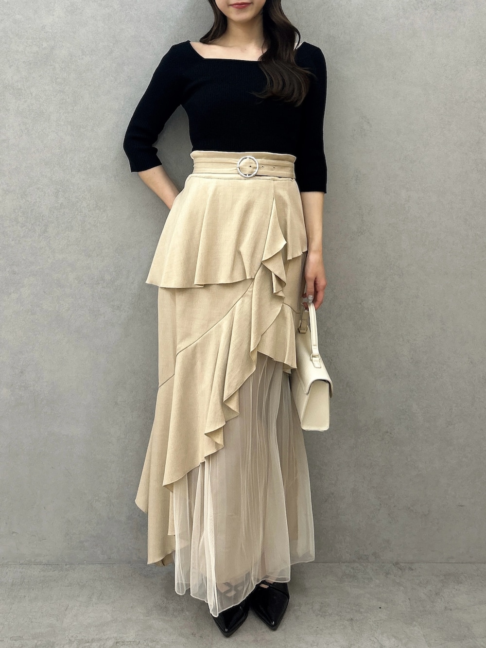 ブラック系のニット/セーター、ベージュ系のスカート、ブラック系のパンプスを着用したレディースの冬コーディネートの5枚目の写真