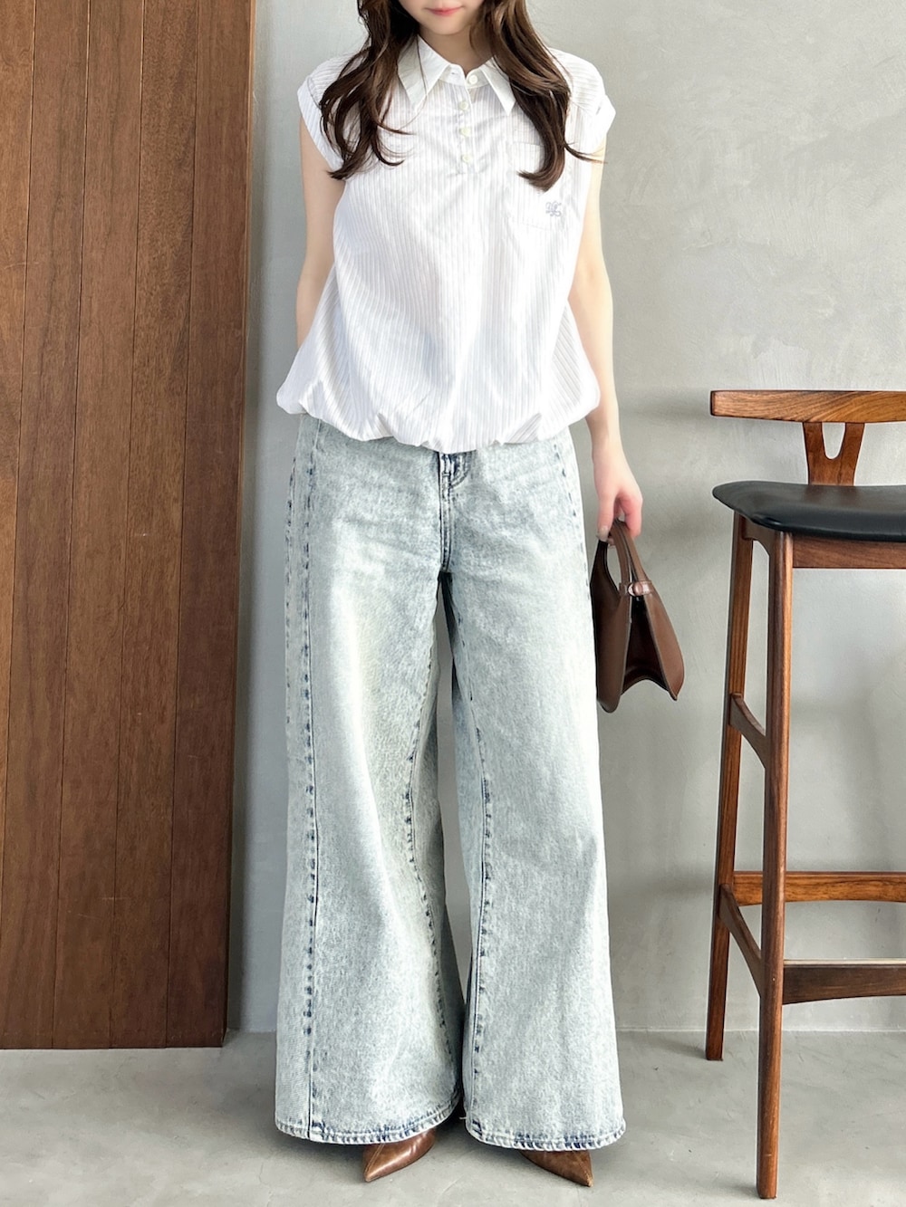 ホワイト系のシャツ/ブラウス、ブルー系のデニムパンツ、ブラウン系のハンドバッグを着用したレディースの春コーディネートの2枚目の写真