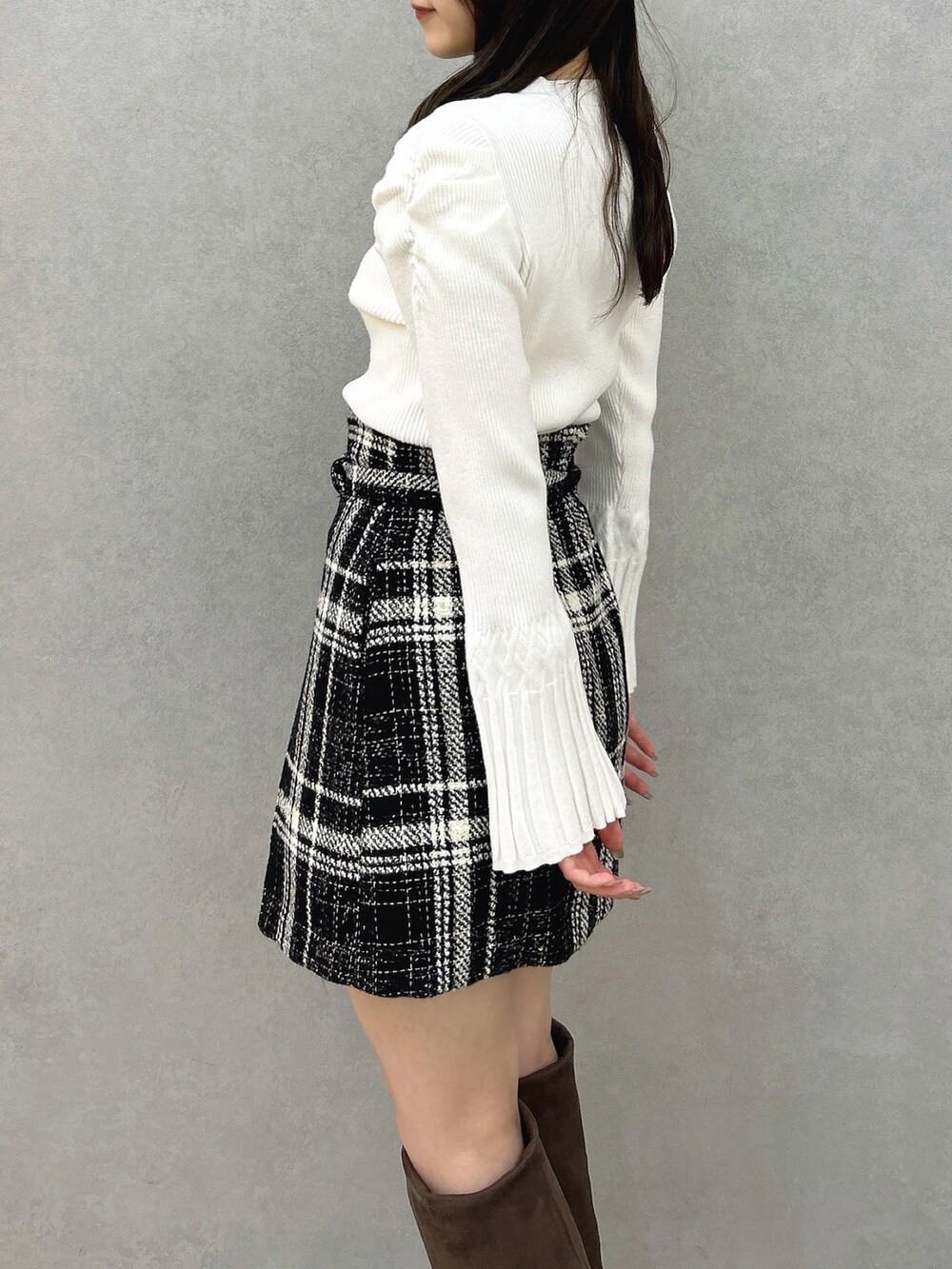 ホワイト系のニット/セーター、ブラック系のスカート、ブラック系のスカートを着用したレディースの冬コーディネートの7枚目の写真